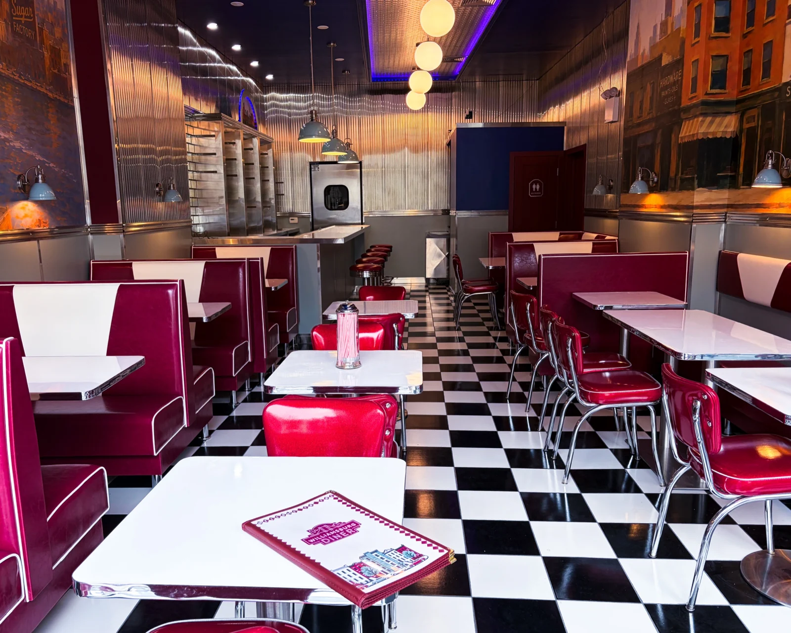 The red booths, checkerboard floor, and chrome details inside Williamsburg Diner
